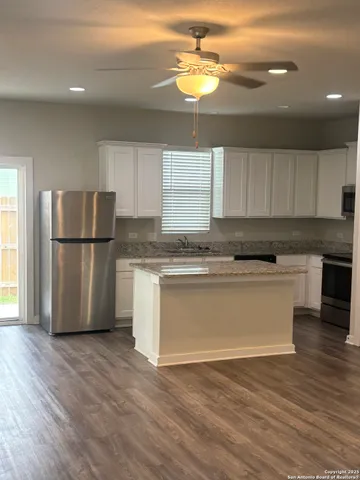a kitchen with a refrigerator cabinets and wooden floor