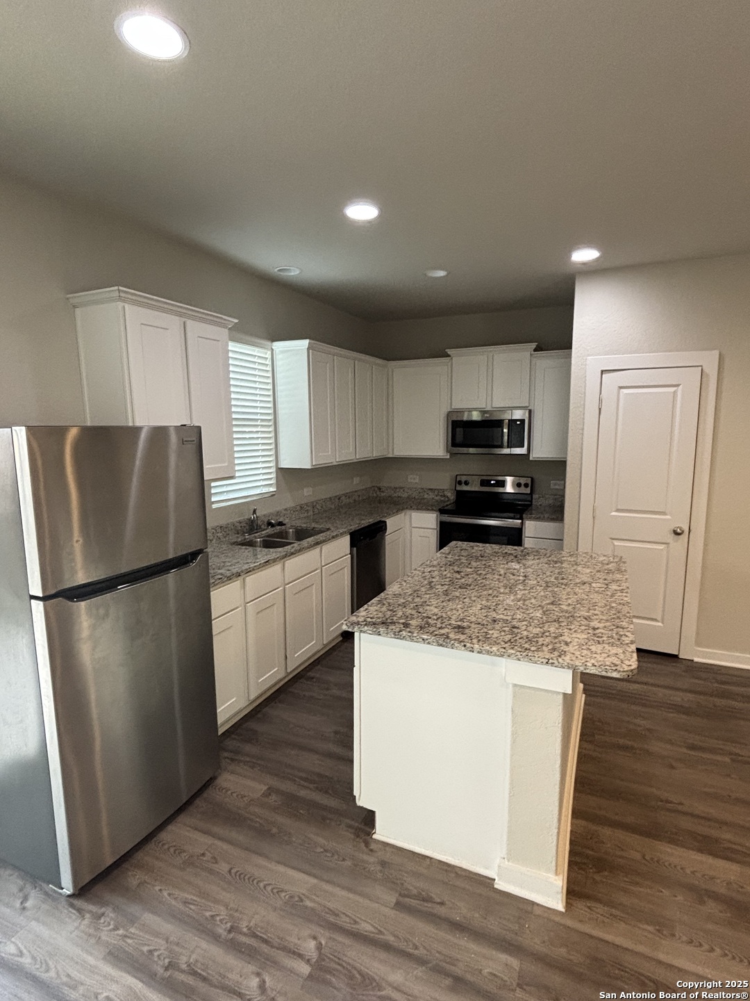 13311 Rowdy Cove, Unit 102 San Antonio, TX 78249 - Photo 5 of 19 a kitchen with stainless steel appliances granite countertop a refrigerator a stove a sink and a microwave