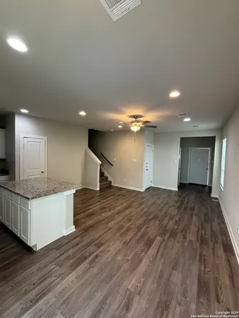 a view of kitchen with kitchen island wooden floor and living room