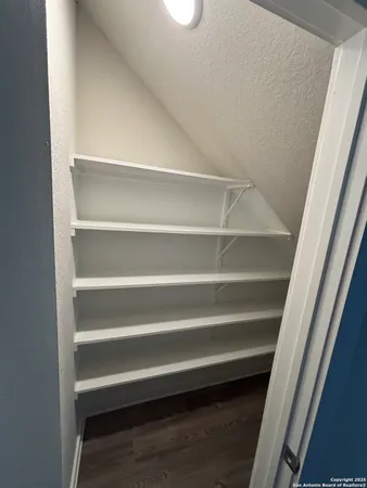 a view of walk in closet with empty racks