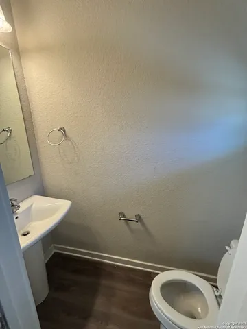 a bathroom with a toilet a sink and mirror