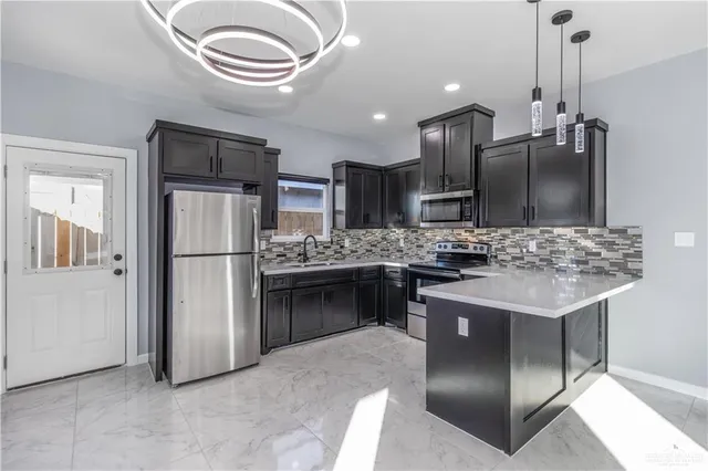 a kitchen with kitchen island stainless steel appliances a sink cabinets and refrigerator