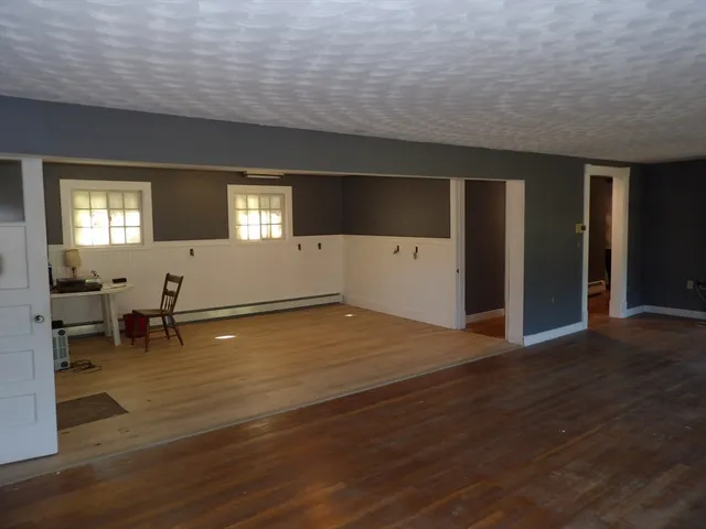 a view of empty room with wooden floor and furniture