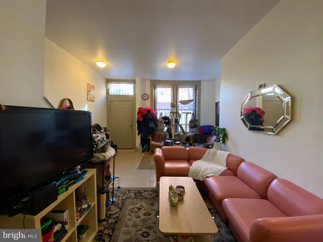a living room with furniture a flat screen tv and a window