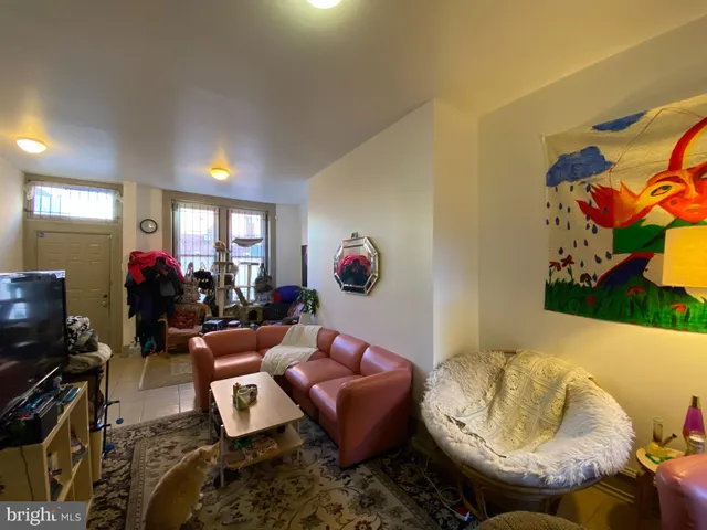 a living room with furniture a potted plant and a window