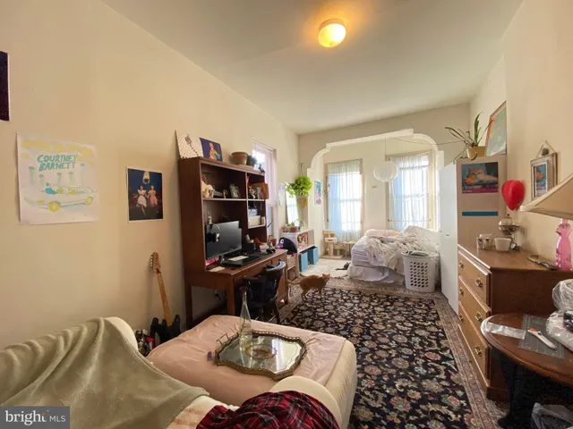 a bedroom with a bed table chair and a window
