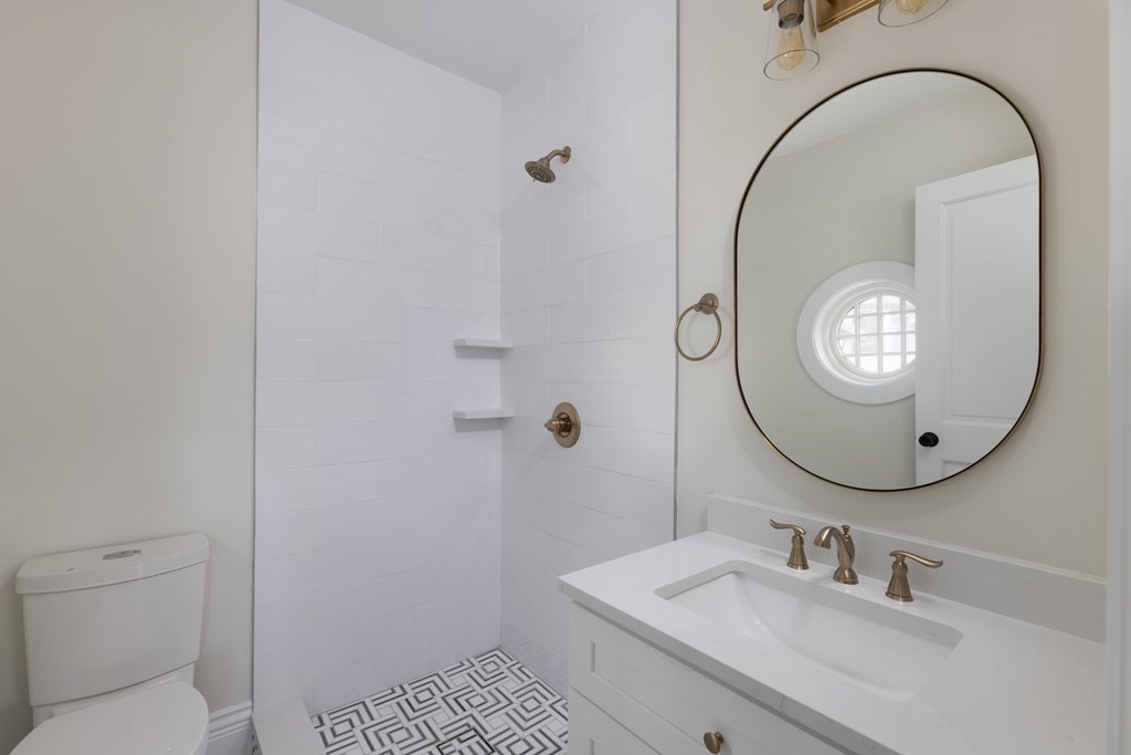 460 Walnut Street Brookline, MA 02445 - Photo 19 of 35 a bathroom with a sink a mirror and a toilet