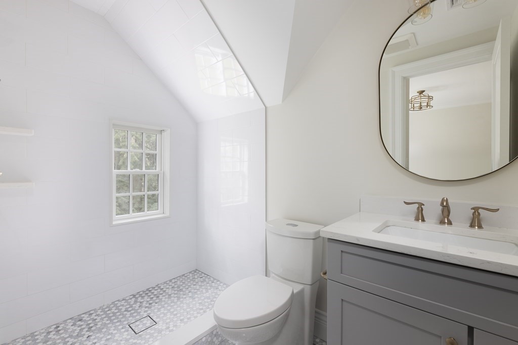 460 Walnut Street Brookline, MA 02445 - Photo 21 of 35 a bathroom with a toilet a sink a mirror and a window