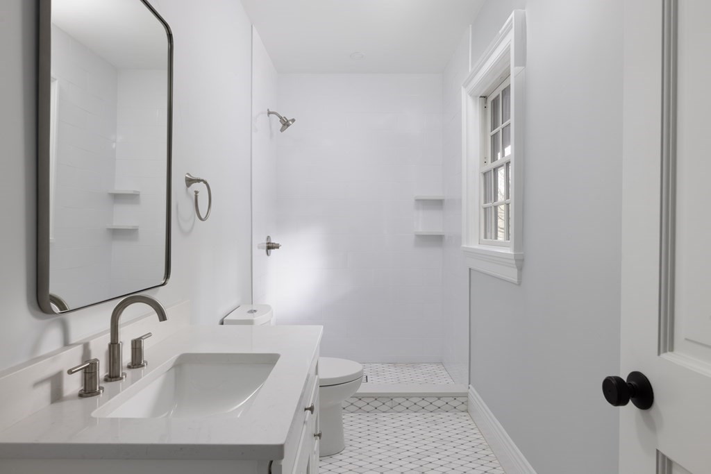 460 Walnut Street Brookline, MA 02445 - Photo 23 of 35 a bathroom with a sink a toilet and a mirror