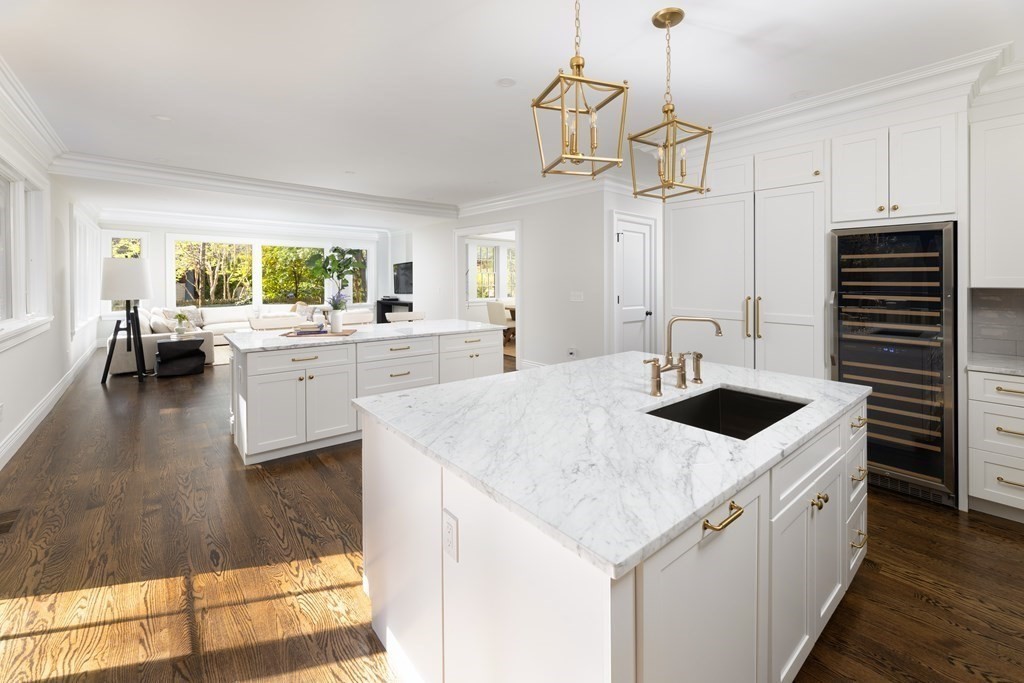 460 Walnut Street Brookline, MA 02445 - Photo 5 of 35 a kitchen with a stove a sink a kitchen island with wooden floor and cabinets