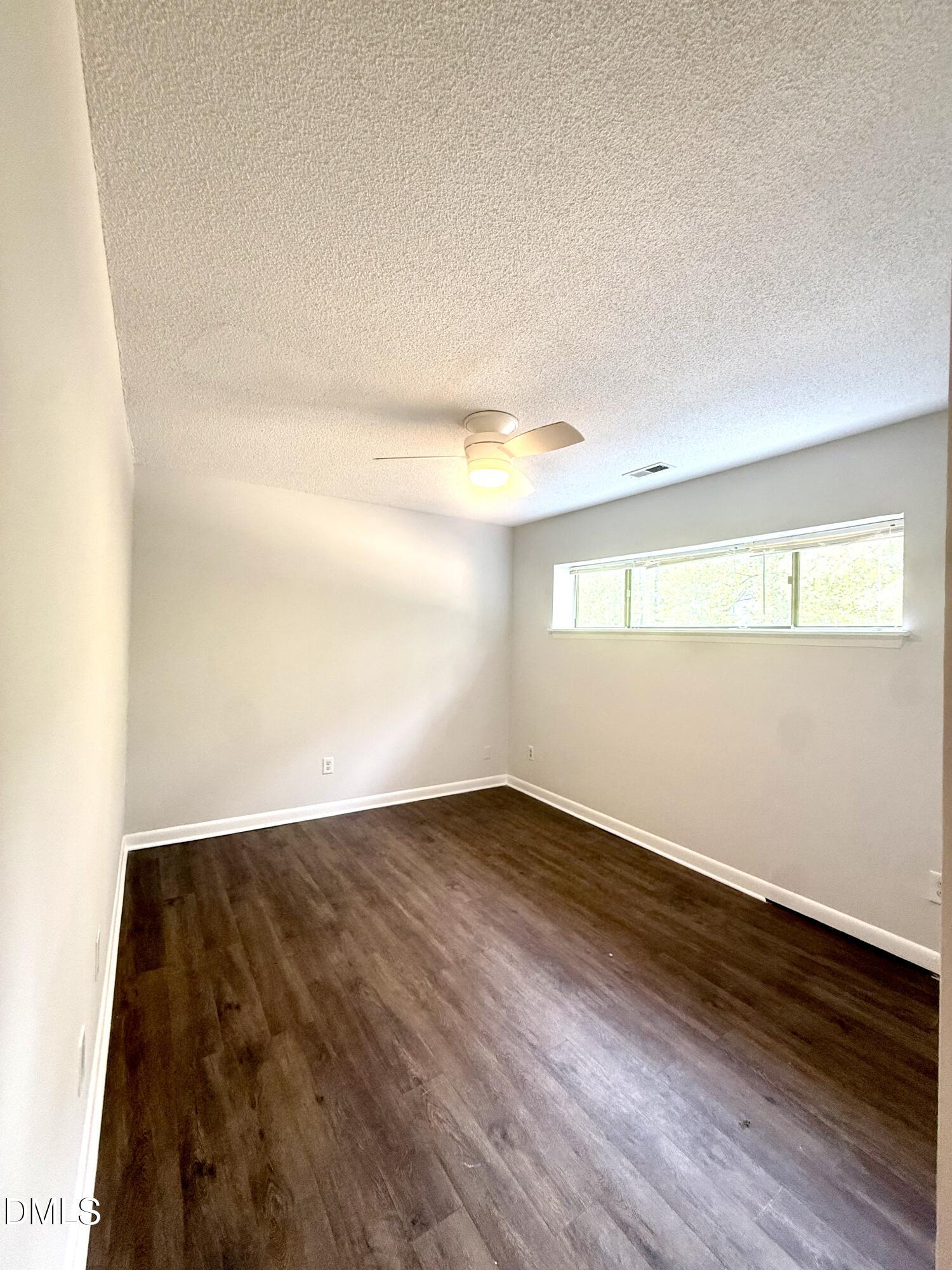 546 Pine Ridge Place Raleigh, NC 27609 - Photo 10 of 28 an empty room with wooden floor and windows
