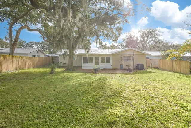a front view of a house with a yard and lake view