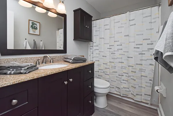 a bathroom with a sink a toilet and shower