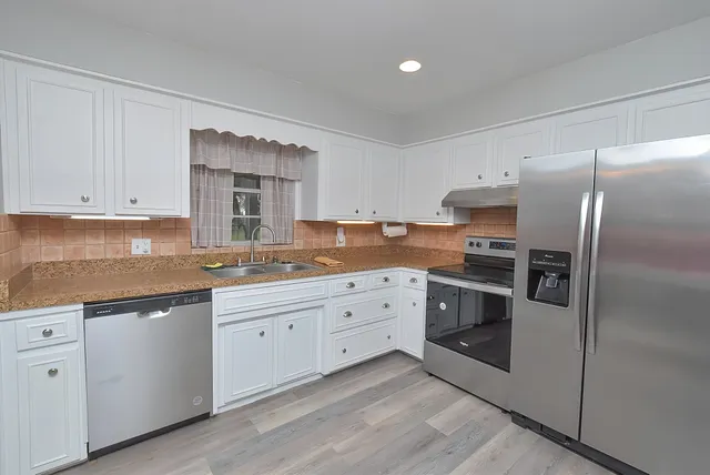 a kitchen with a sink stove and cabinets