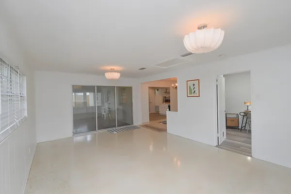 an empty room with windows and fireplace
