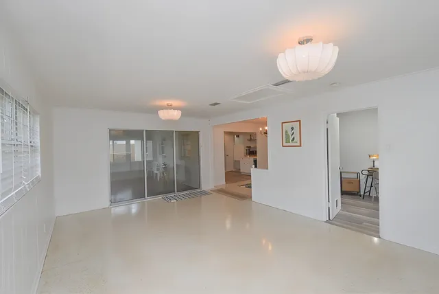 an empty room with windows and fireplace