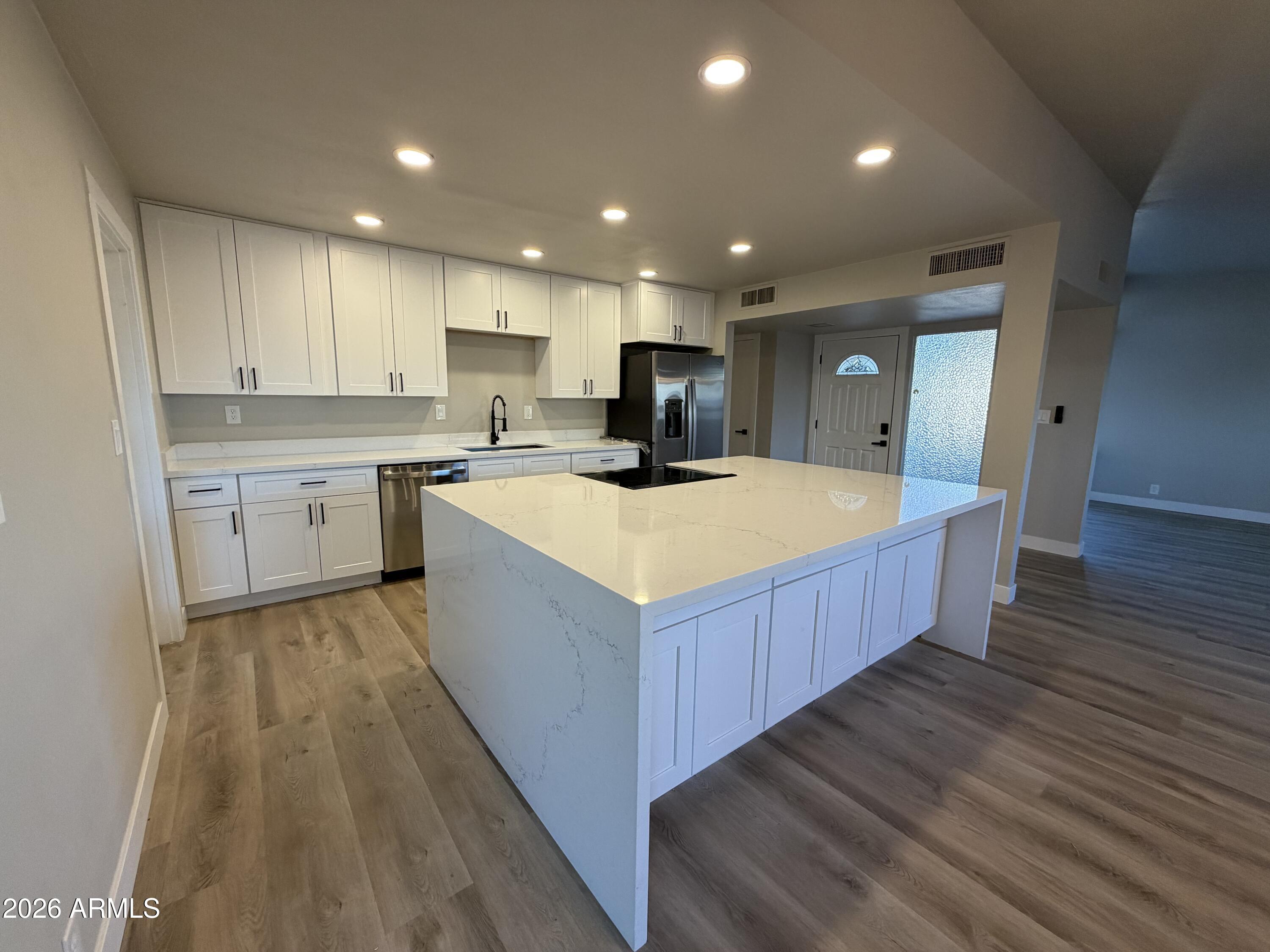 5420 North Granite Reef Road Scottsdale, AZ 85250 - Photo 2 of 30 a large kitchen with kitchen island a sink a counter top space and cabinets