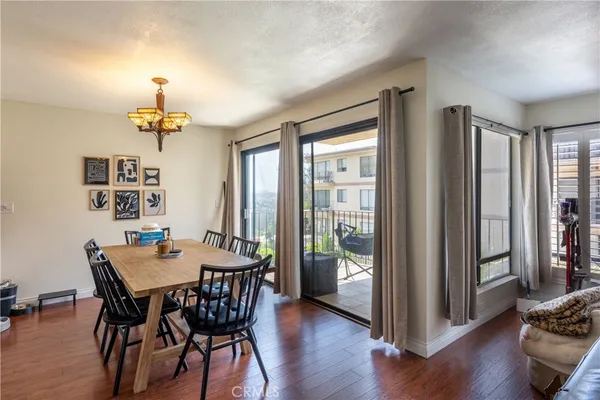 a dining room with furniture a chandelier and wooden floor
