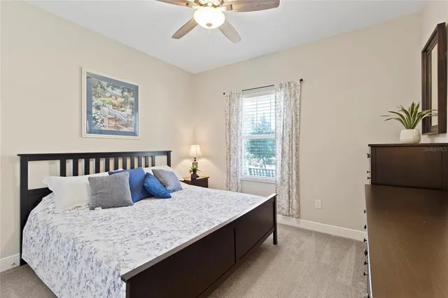 a large bed sitting in a bedroom next to a window with a chandelier