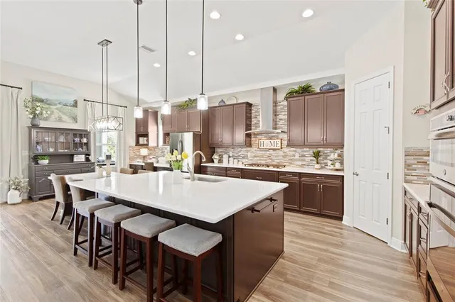 a large kitchen with kitchen island a island a stove a table and chairs in it