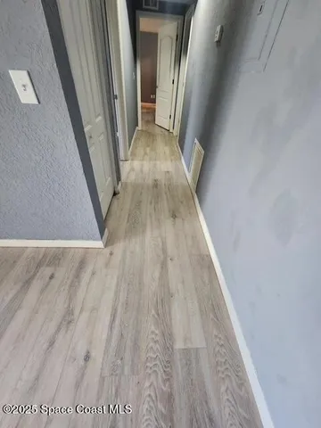 a view of a hallway with wooden floor