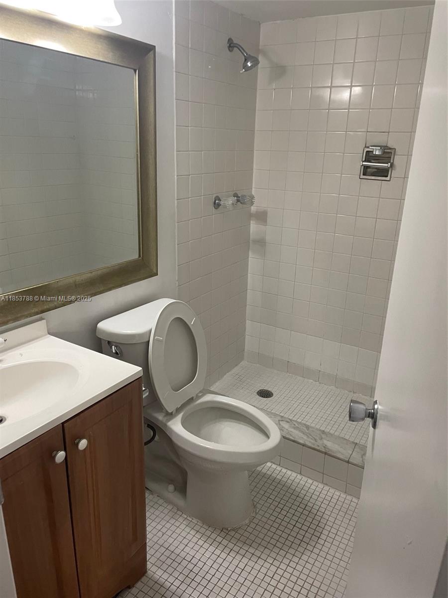 1075 Riverside Drive, Unit 203 Coral Springs, FL 33071 - Photo 3 of 9 a bathroom with a double vanity sink toilet and shower