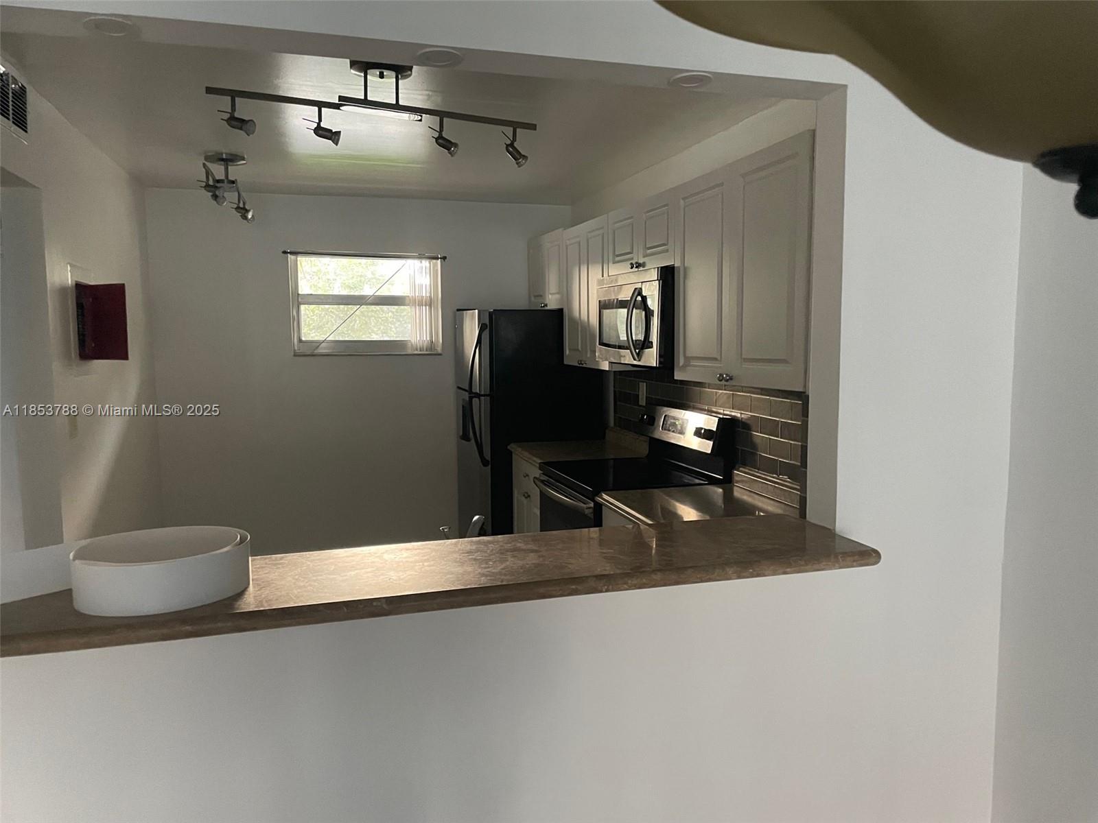 1075 Riverside Drive, Unit 203 Coral Springs, FL 33071 - Photo 4 of 9 a bathroom with a sink and a mirror