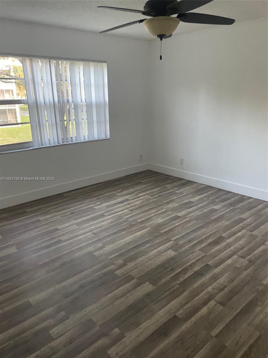 1075 Riverside Drive, Unit 203 Coral Springs, FL 33071 - Photo 7 of 9 wooden floor in an empty room