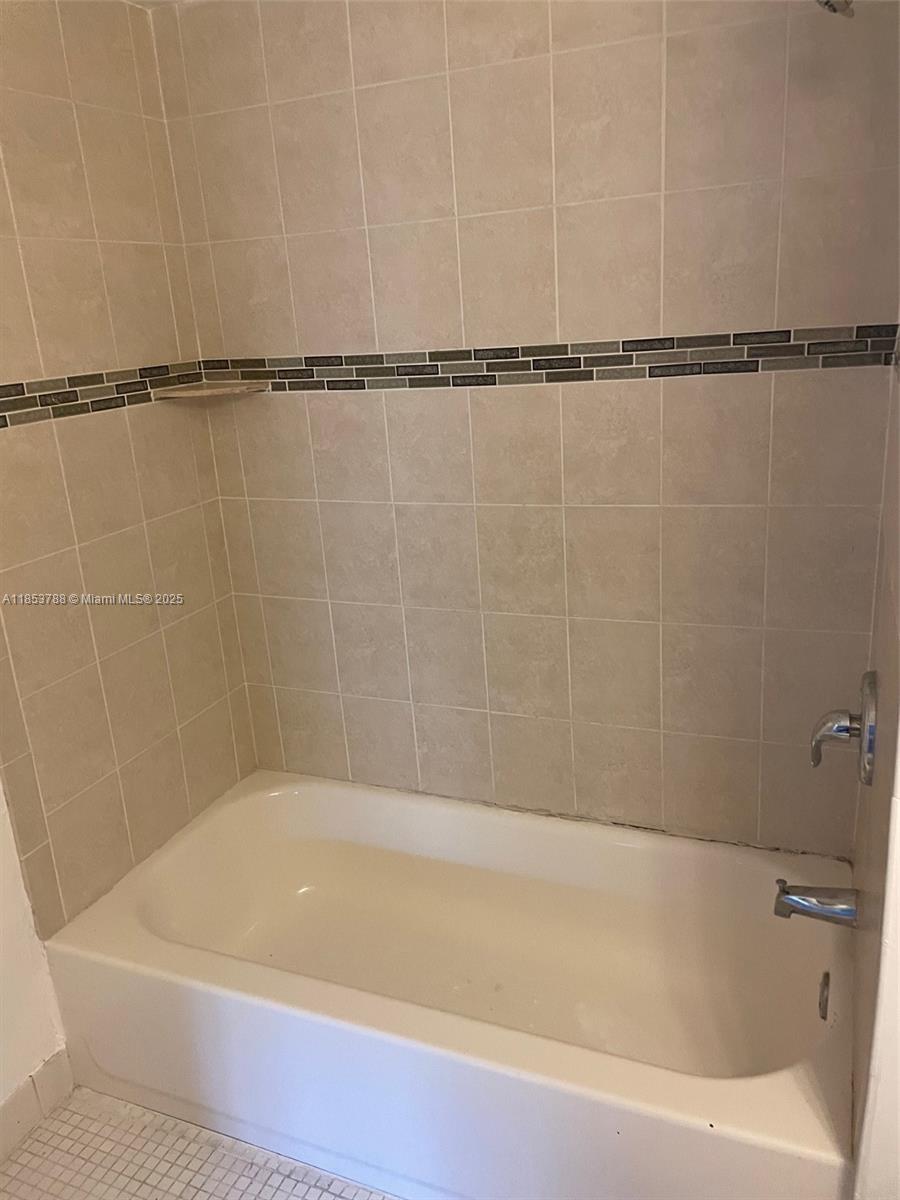 1075 Riverside Drive, Unit 203 Coral Springs, FL 33071 - Photo 8 of 9 a bathroom with a shower and a bath tub