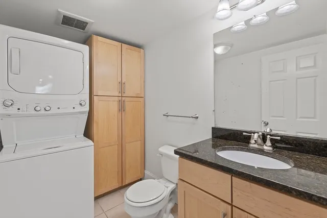 a bathroom with a granite countertop sink toilet and mirror