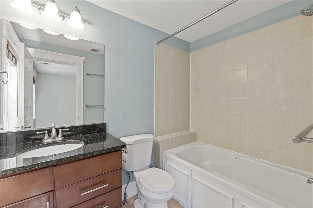 45 Ward Street Boston, MA 02127 - Photo 10 of 16 a bathroom with a granite countertop sink a toilet a mirror and bathtub