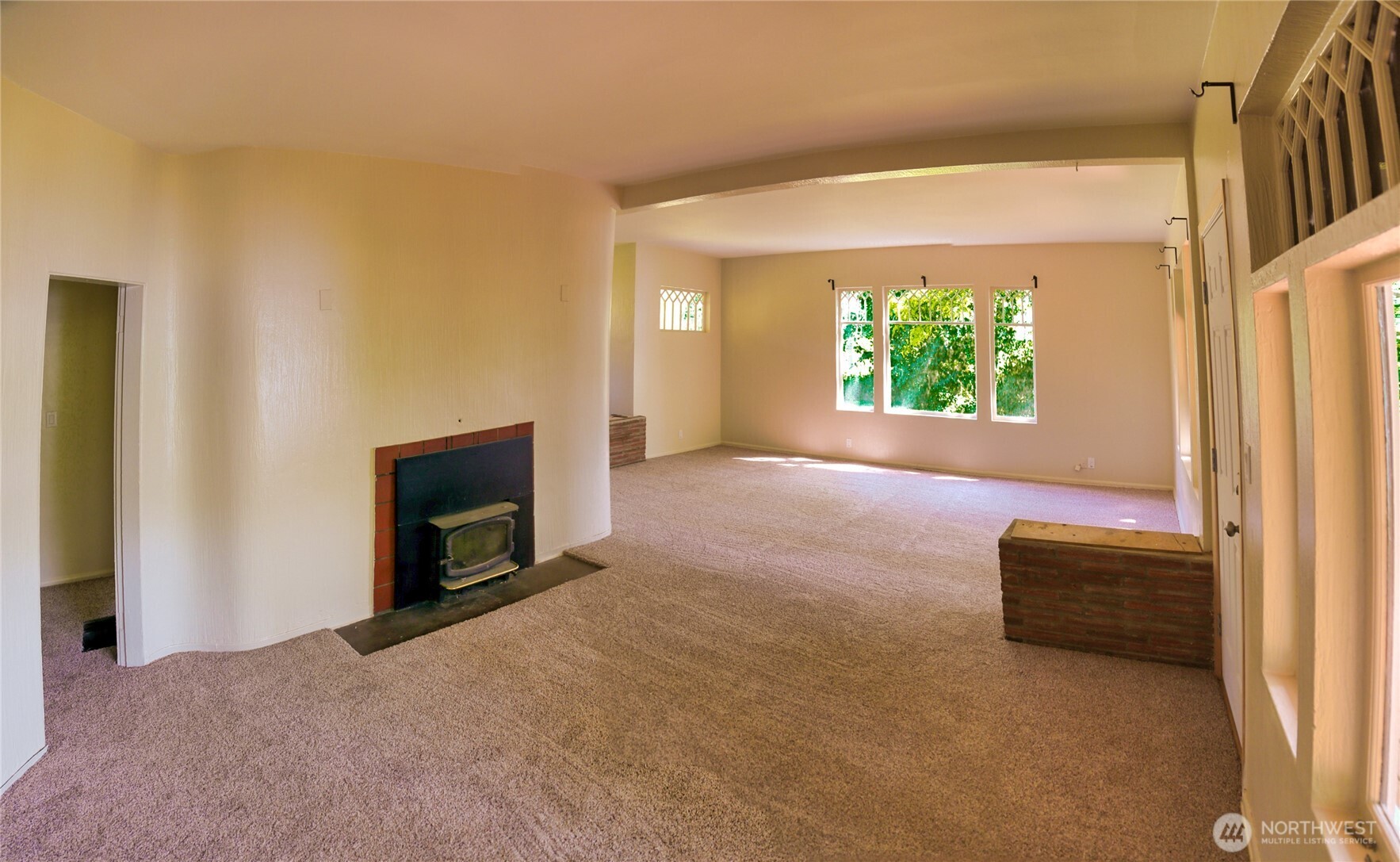 6810 Northeast Bergman Road Bainbridge Island, WA 98110 - Photo 11 of 24 a view of an empty room with windows and a fireplace