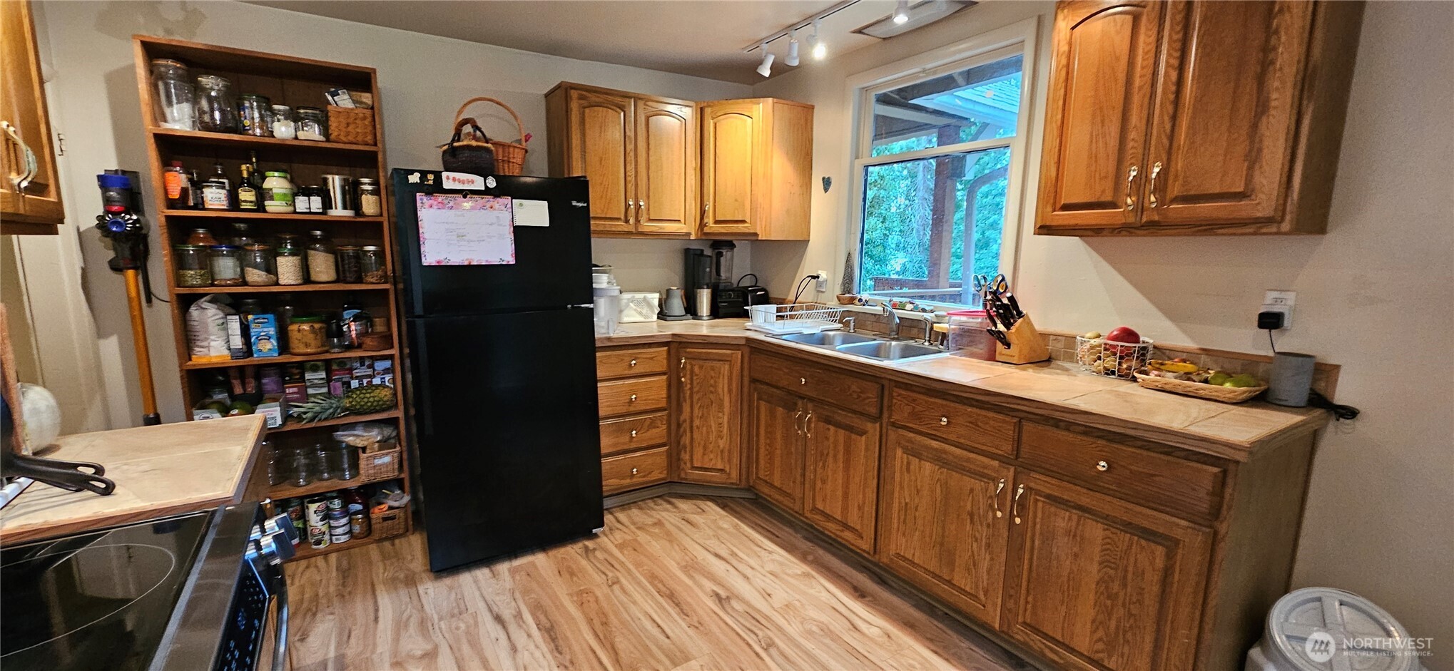 6810 Northeast Bergman Road Bainbridge Island, WA 98110 - Photo 23 of 24 a kitchen with stainless steel appliances granite countertop a refrigerator a sink dishwasher a stove and a dining table with wooden floor