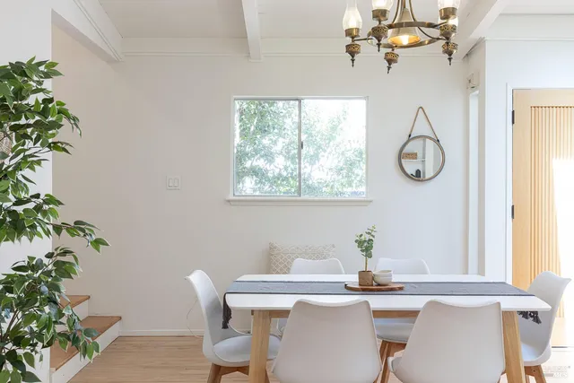 a dining room with furniture potted plants and a chandelier