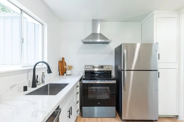 a kitchen with stainless steel appliances a refrigerator sink and cabinets