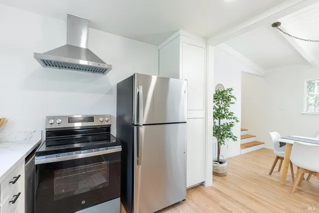 a kitchen with a refrigerator and a chair