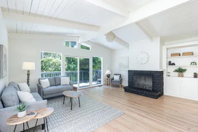 a living room with furniture a large window and a fireplace