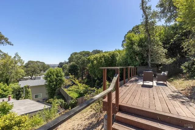 a view of a balcony with two chairs and a wooden fence