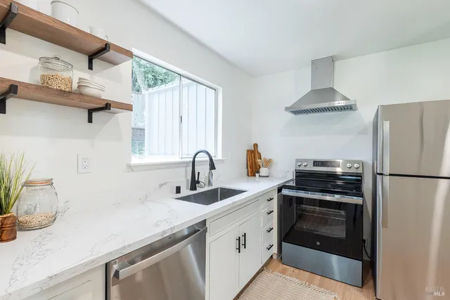a kitchen with stainless steel appliances a sink a stove and a refrigerator