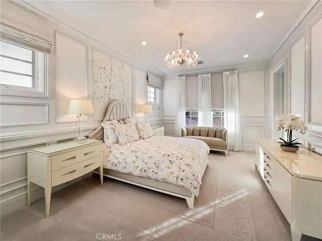 a bedroom with bed and a chandelier