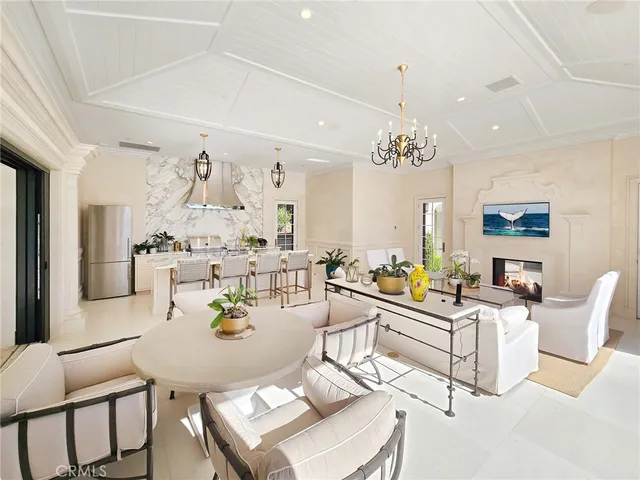 a living room with furniture a chandelier and a dining table