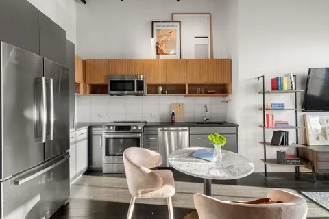 a kitchen with stainless steel appliances granite countertop a sink a stove a refrigerator and a refrigerator