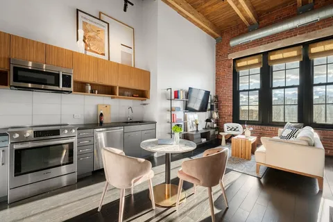 a kitchen with stainless steel appliances wooden floor dining table and chairs