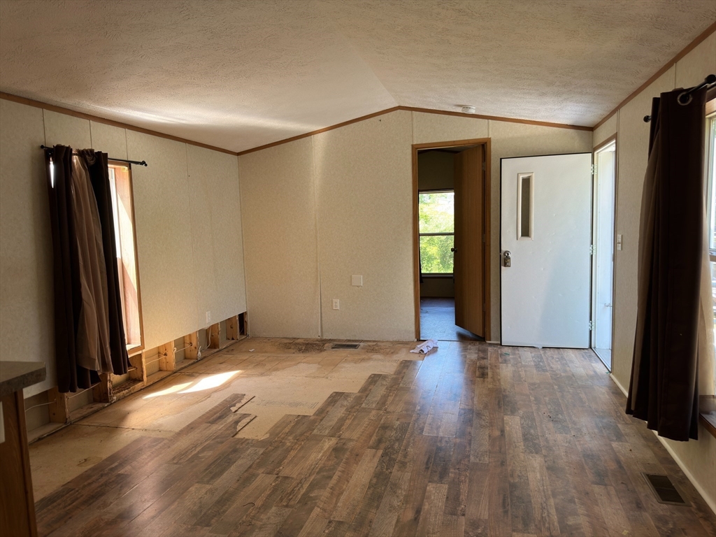 46 Madden Road, Unit 2 West Brookfield, MA 01585 - Photo 5 of 22 an empty room with wooden floor and a fireplace