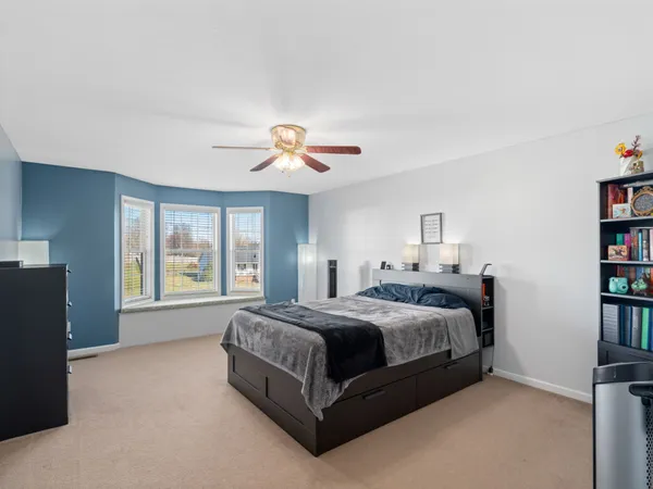 a spacious bedroom with a bed and a large window