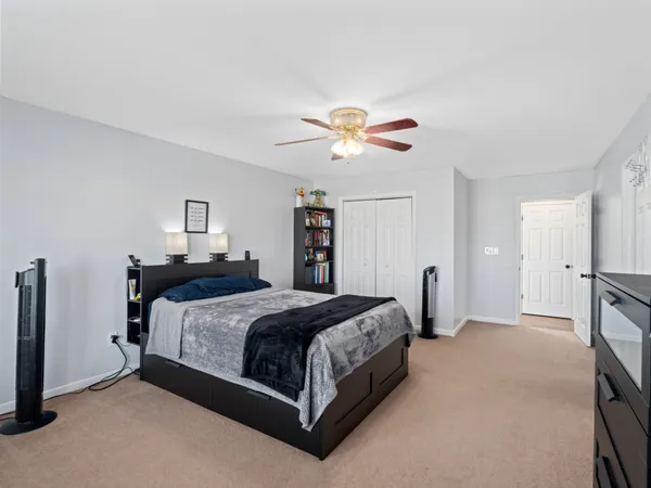 a spacious bedroom with a bed and a chandelier
