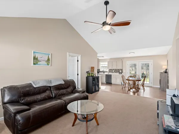 a living room with furniture a ceiling fan and a window