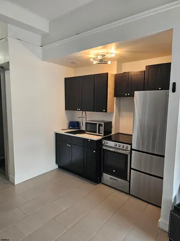 a kitchen with stainless steel appliances a refrigerator and a stove top oven