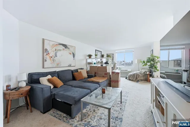 a living room with furniture and a painting on the wall