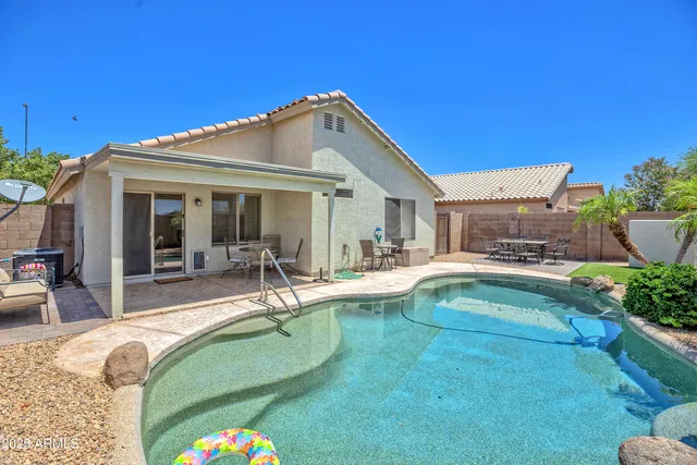 a view of a house with swimming pool and sitting area